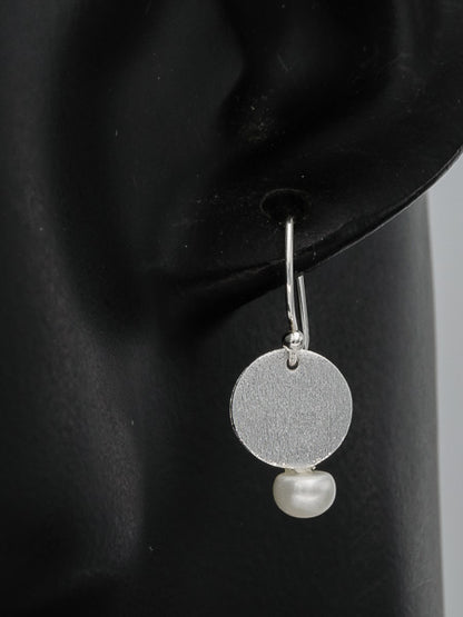 Dangling brushed silver disc with a pearl