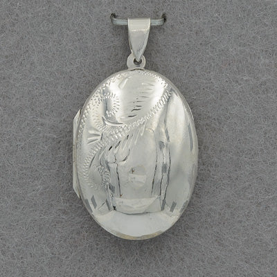 Silver locket with engraved design on a gray background