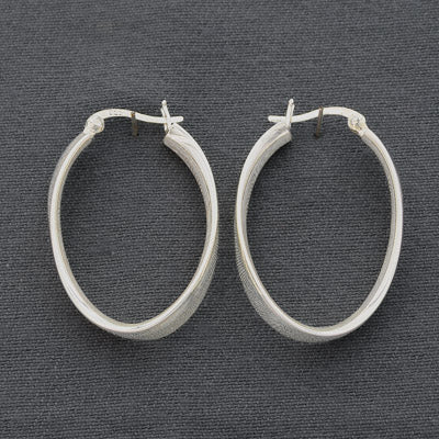 Sterling silver flat hoop with a twist