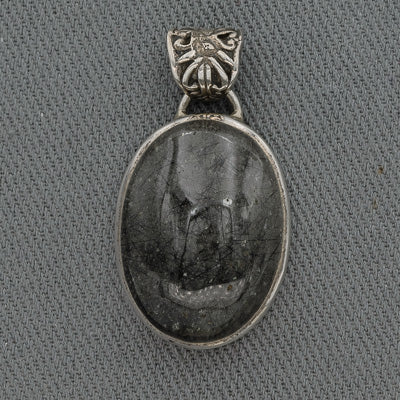 An oval-shaped black rutilated quartz pendant set in sterling silver with a decorative silver loop and bail.