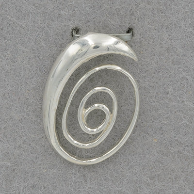 Silver spiral pendant on a gray background