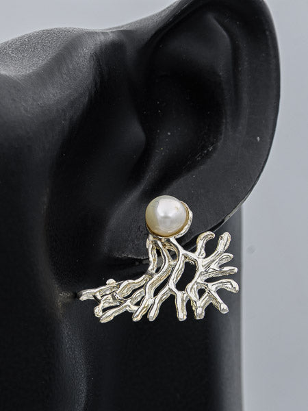 A silver-toned branch or coral-like stud earring with a single white pearl, displayed on a black ear-shaped mannequin against a light gray background.