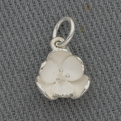 A sterling silver pendant in the shape of a petite white flower with polished edges.