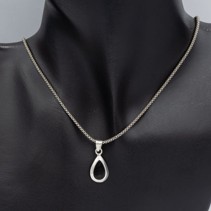 A silver teardrop pendant necklace on a matching silver chain, displayed on a black mannequin bust against a neutral gray background.