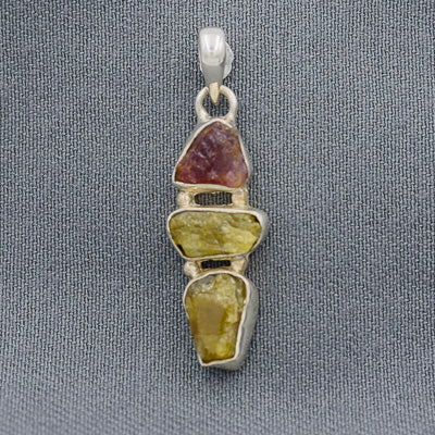 Pendant with multicolored stones on a gray background