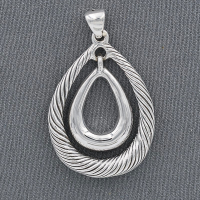 Silver pendant with intricate design on a gray background