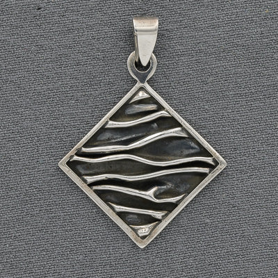A sterling silver square pendant with oxidized patterns and a polished edge on a grey background.