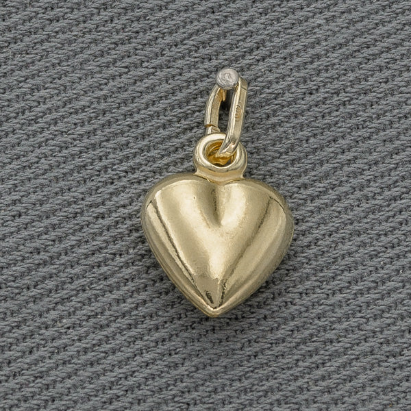 Gold heart-shaped pendant on a gray textured background