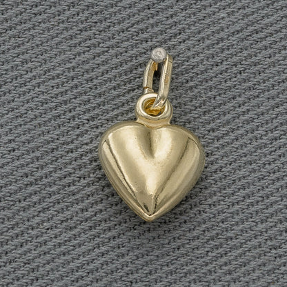 Gold heart-shaped pendant on a gray textured background
